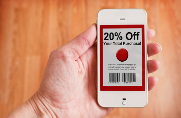 A hand holding a smartphone with a digital coupon on the display.