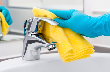 Woman doing chores in bathroom, cleaning tap
